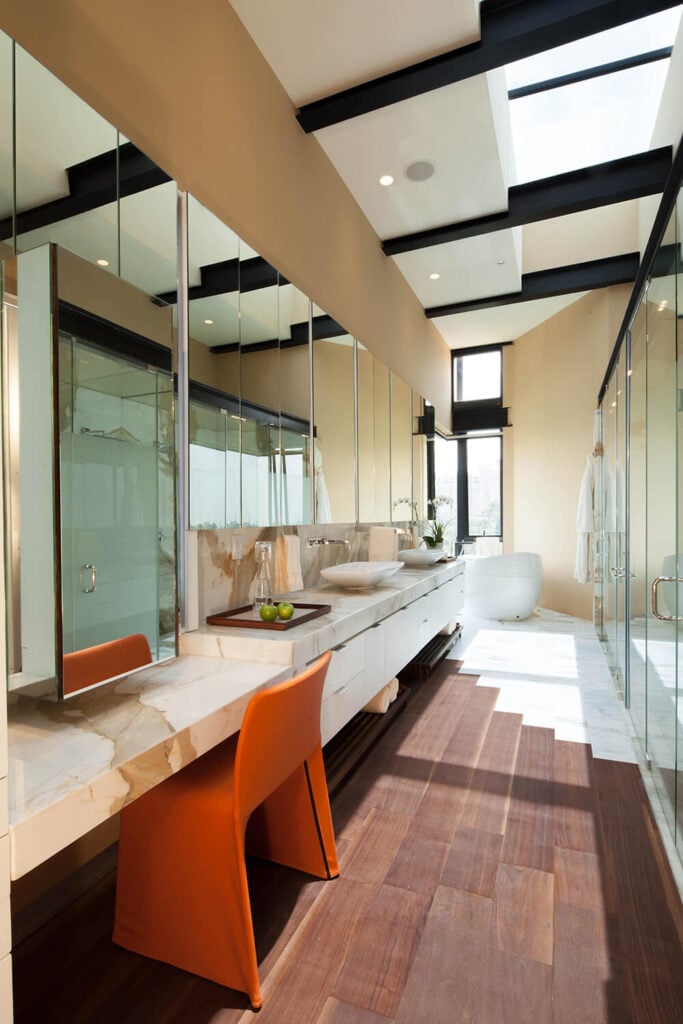 主浴室铺满了奢华的大理石和玻璃，里面有一个长长的梳妆台，对面是一排步入式淋浴间和浴室区。硬木地板让位给白色大理石，因为它接近底座浴缸。