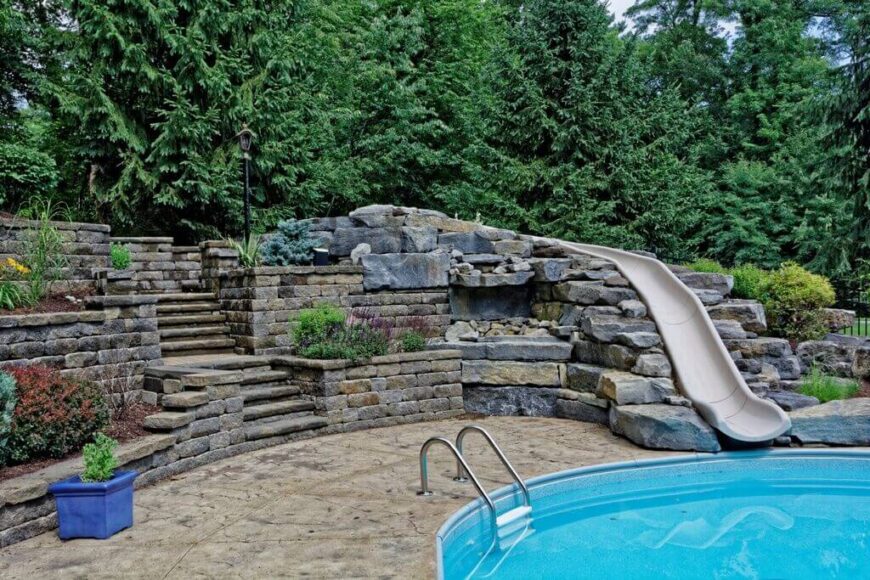 一条笔直的滑道从这些石头的顶部，穿过院子，进入游泳池。这是一个很好的例子，利用景观美化和石材工作，把一个滑梯融入到你院子的其他部分。