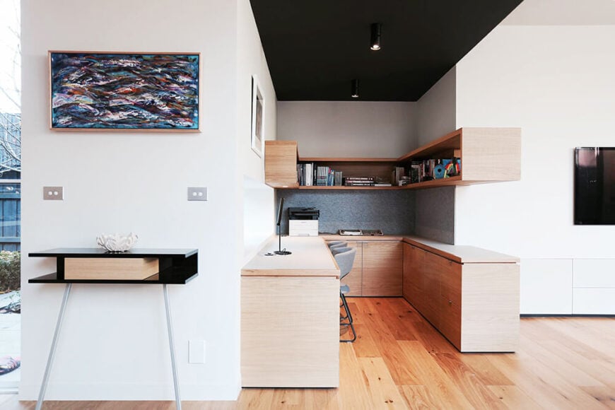 开放式的重新设计提供了优雅，巧妙的帅气空间，就像这个家庭办公室，隐藏在一个更大的开放房间的一个海湾里。光滑的天然木橱柜定义了这个区域，通过硬木地板和纯净的白墙连接到更广阔的住宅。