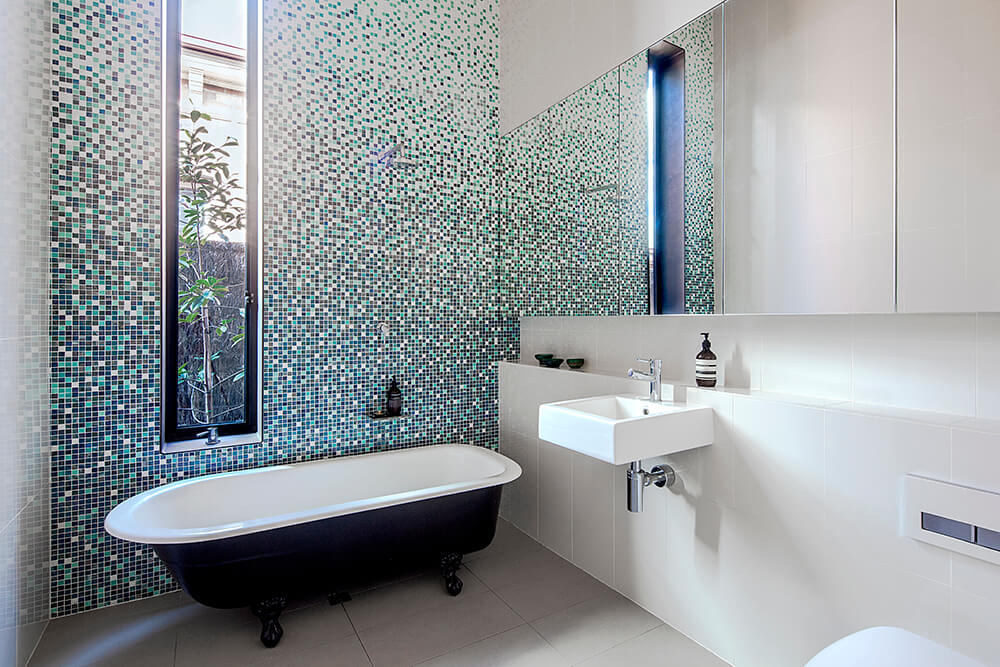 该浴室设有一个非常迷人的瓷砖墙，在独立式浴缸附近。浮动容器水槽看起来也绝对令人惊叹。