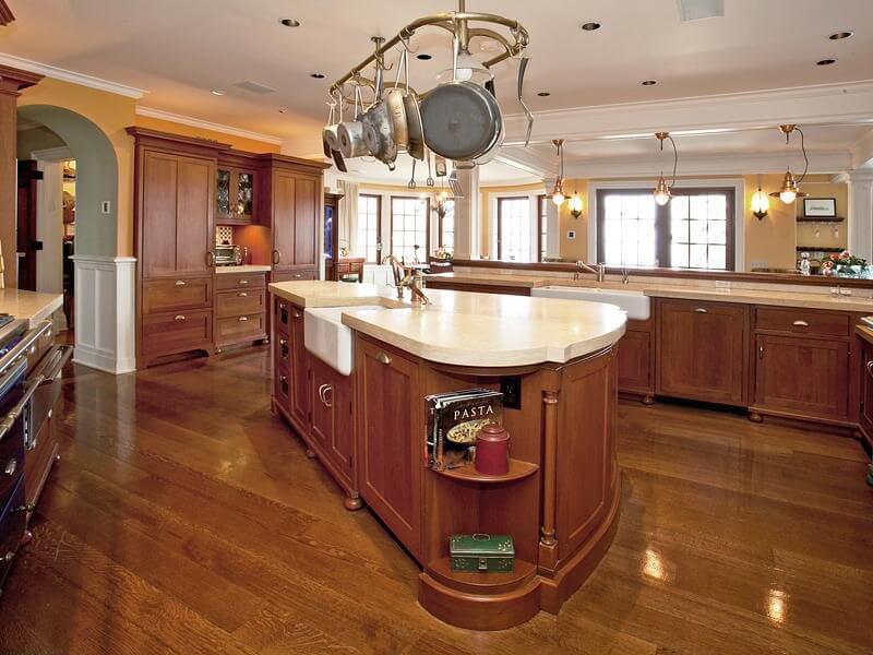 苍白的实心台面与厨房其余部分的丰富木材形成对比。