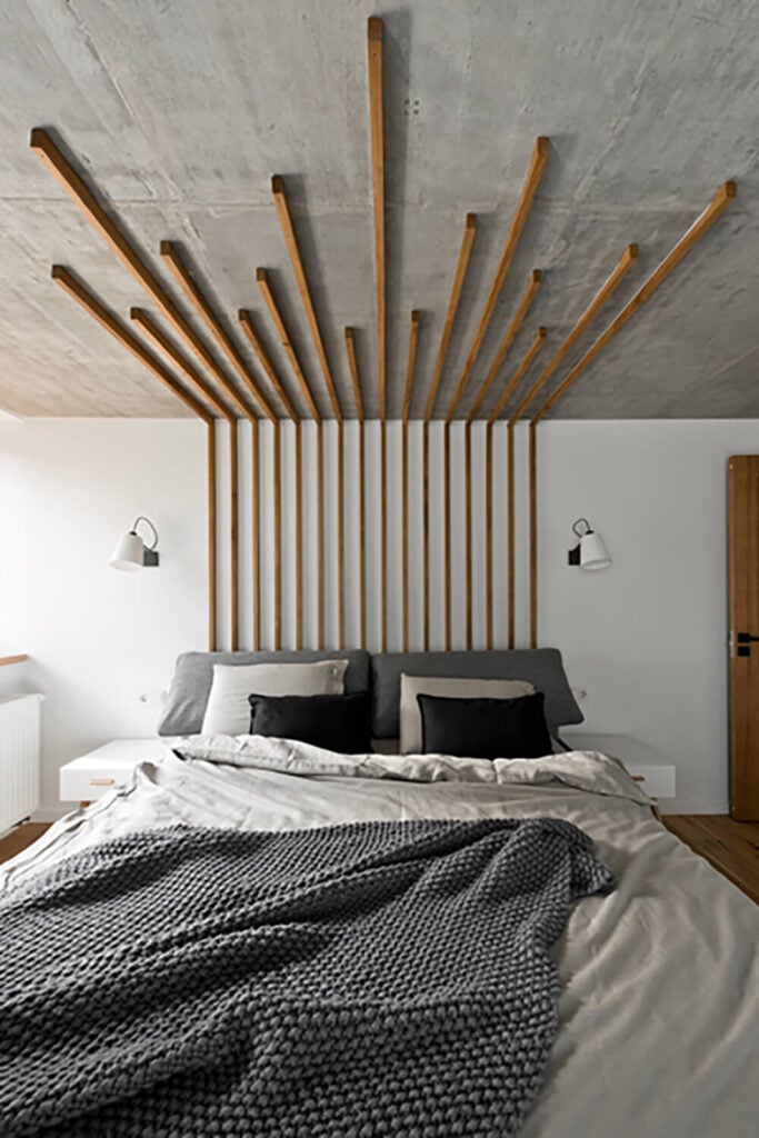 主卧室采用了另一种独特的薄天然木条，从假床头板设计延伸到天花板。这将整个房间包裹成一件实用的艺术品。