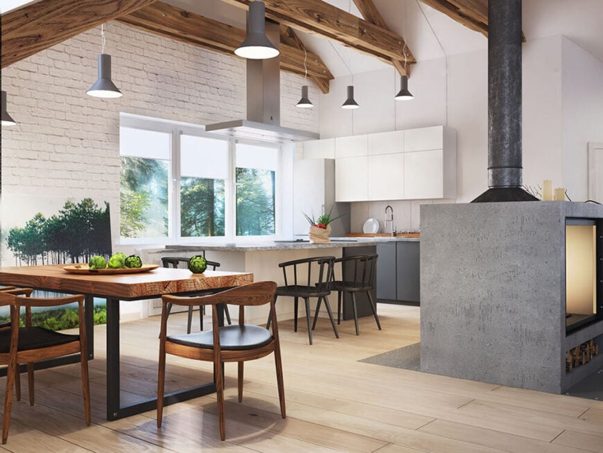 厨房里有光滑的白色橱柜和石材台面，冷色调与周围丰富的硬木地板形成鲜明对比。在左边，餐桌采用了丰富的木材和黑色金属框架。