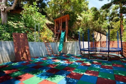 这个空间是孩子们玩耍的完美场所。这个户外空间的地面是软垫的，使它非常适合孩子，蹦床甚至更安全。如果有人从蹦床网上掉下来，蹦床的地板是软垫的，地面不是硬的。 