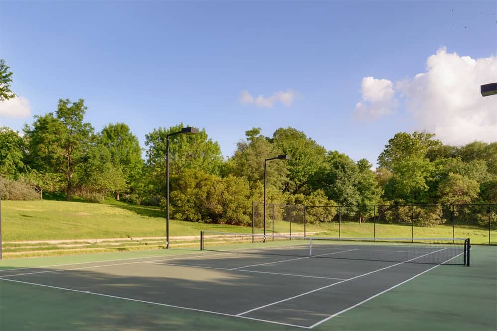 这是该庄园的大型网球场，周围是郁郁葱葱的草地和高大的树木，形成了可爱的背景。图片来自Toptenrealestatedeals.com。
