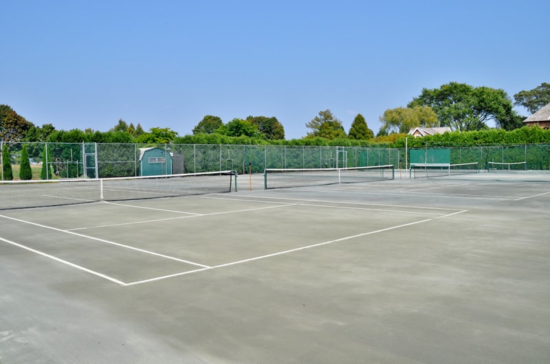 这是一个巨大的开放区域，可以容纳三个网球场。整个区域用网围起来，装饰着高大的绿色树木，与混凝土地板相辅相成。