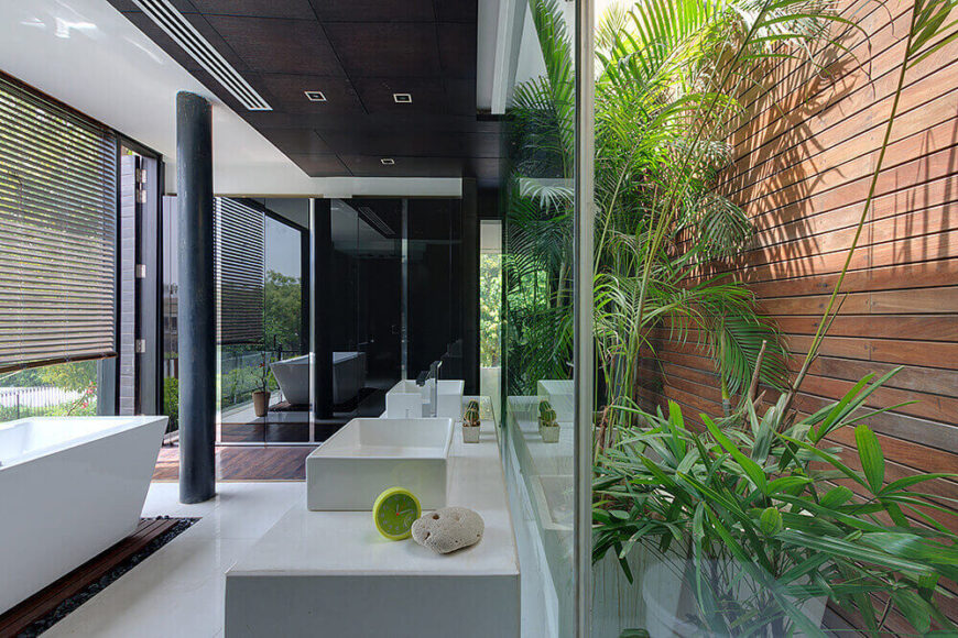 主浴室是一个引人注目的现代空间，混合了玻璃、白色大理石、丰富的天然木材和一排排明亮的绿色植物。左边的底座浴缸可以欣赏到大自然的全景。