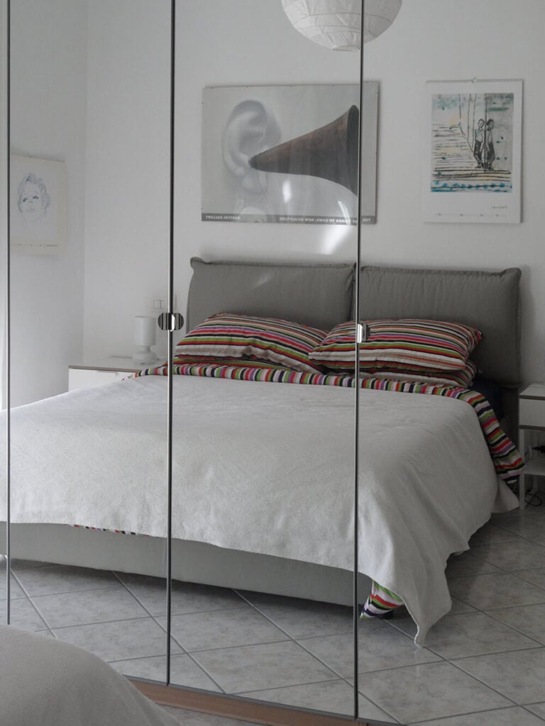 卧室也是一个简单而优雅的空间，兼具极简特色和现代特色。高大的镜子似乎增强了空间，让它感觉宽敞。这与精心安排的流动相结合，使这个小空间有一种通风的感觉。