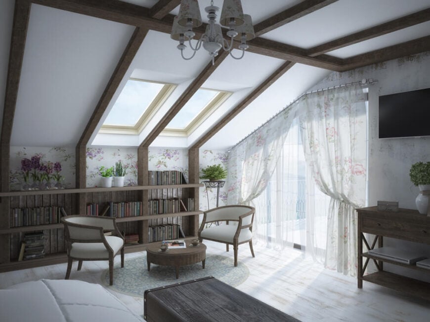 这间卧室最吸引人的地方是倾斜的天花板、天窗和宽阔、形状不规则的玻璃阳台门。这样可以在高对比度的房间里获得充足的阳光。在左边，一个独特的深色木质书架嵌在墙上。