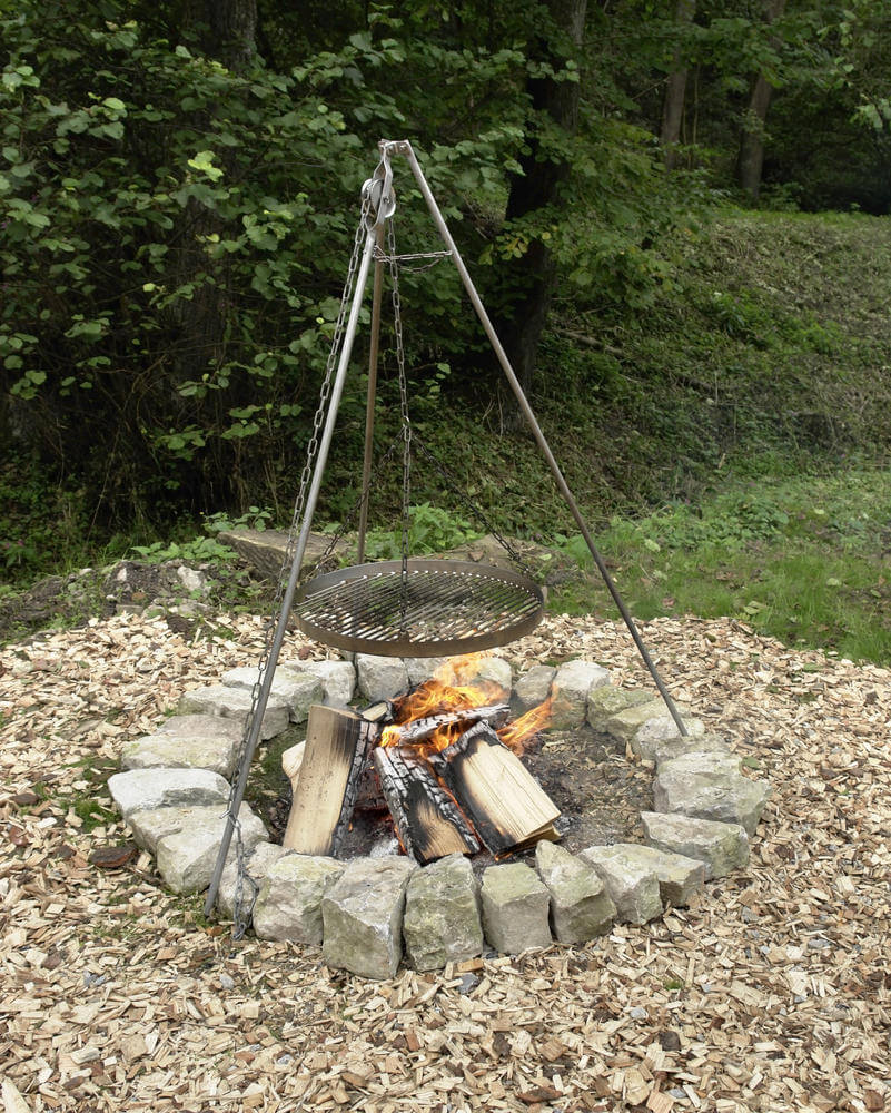 一个用石头建造的非常简单的圆形火坑，包括一个悬挂在帐篷结构上的烹饪格栅。