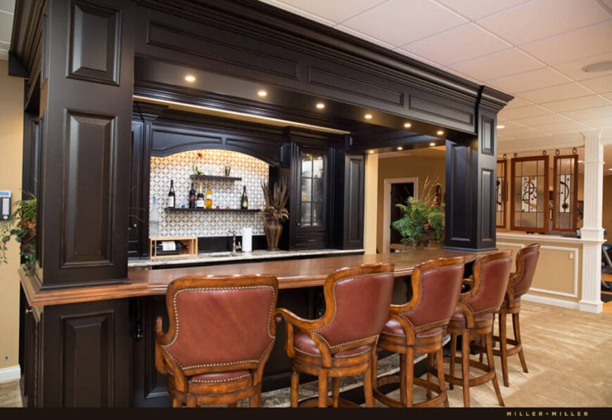 豪华风格的全酒吧提供丰富的木质座椅，深色橱柜，和一个巨大的酒吧顶部空间与客人和朋友互动。它坐落在厨房、游泳池和家庭健身房附近的一个开放区域，是一个很棒的社交中心。