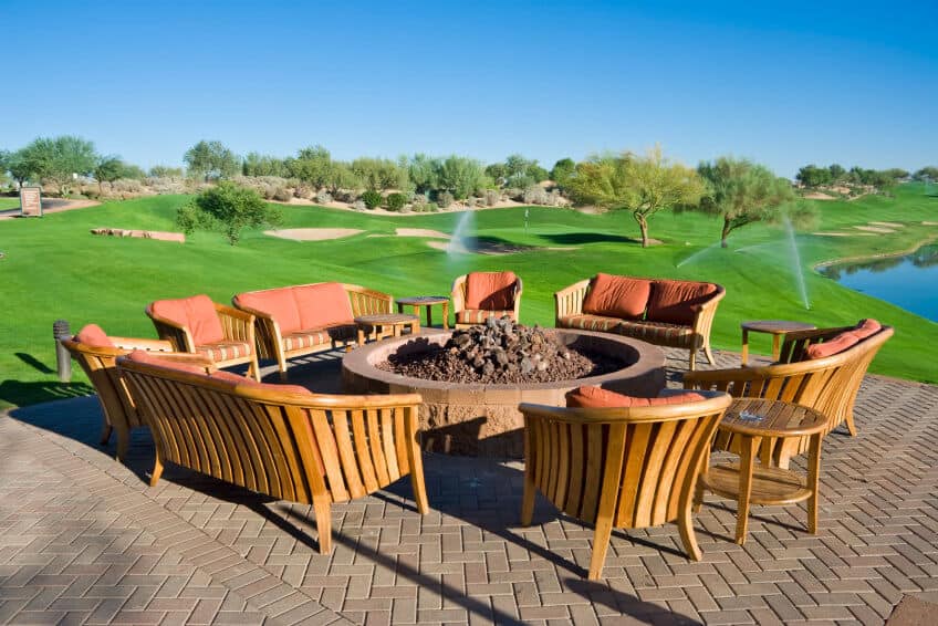 大圆形的棕色砖火坑在匹配的砖露台上，俯瞰高尔夫球场。