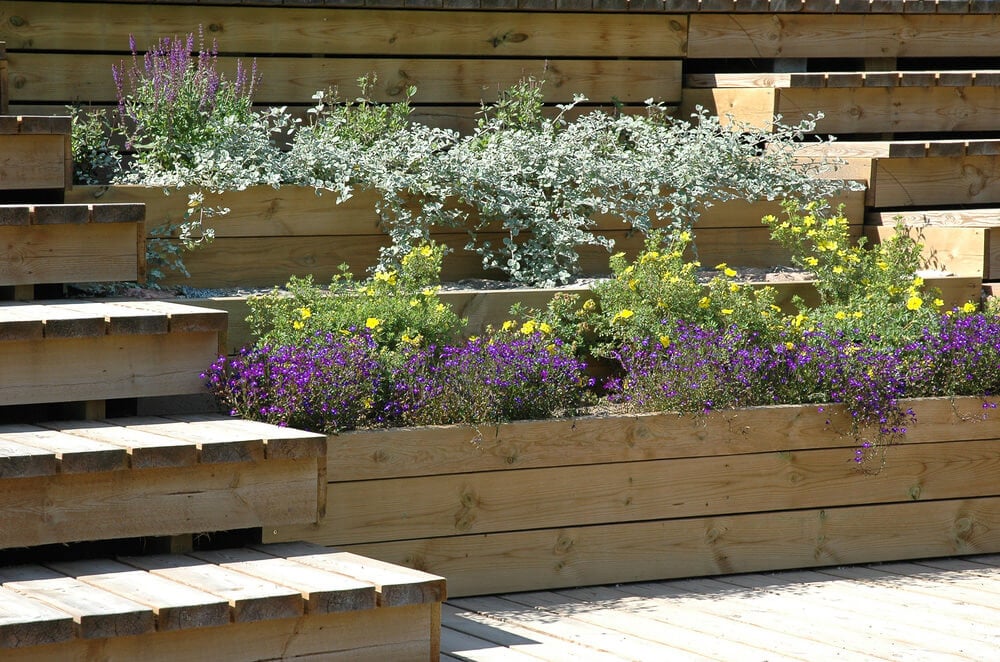 这个分层的露台木花盆是一个极好的方式来边界在小后院的甲板。