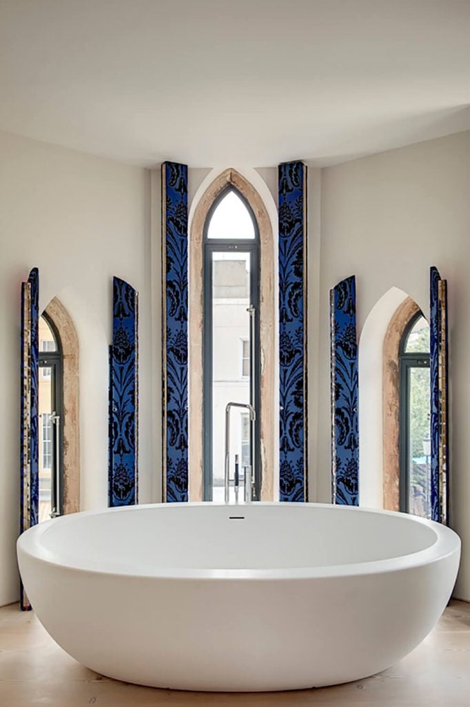 主浴室设有三扇拱形窗户，可以让充足的光线进入，但足够狭窄，仍然可以为沐浴者提供足够的隐私。蓝色百叶窗保证了完全的隐私。
