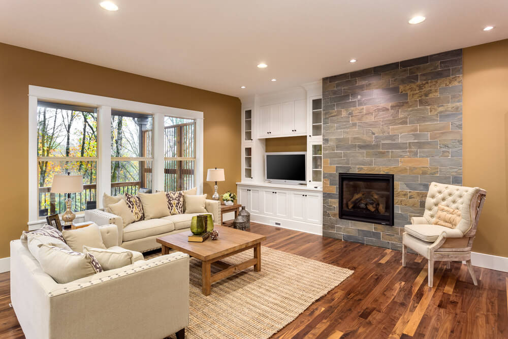 宽敞的客厅设有硬木地板，典雅的座椅和壁炉，周围是棕色的墙壁。