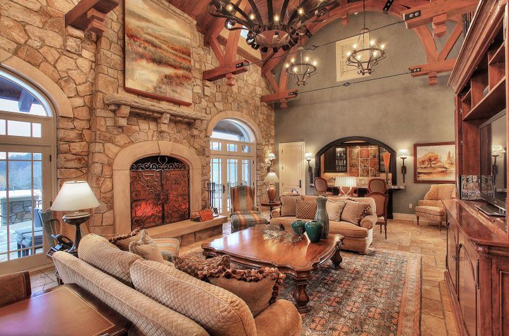 一个乡村和传统的灵感室内大胆和详细的木材和石头设计。在家具上可以看到一些雕刻，传统的沙发、灯罩、吊灯和壁炉增添了古老和优雅的感觉。