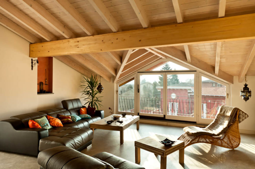 在这里，较轻的松木梁支撑着这个阁楼家庭娱乐室的拱形屋顶。