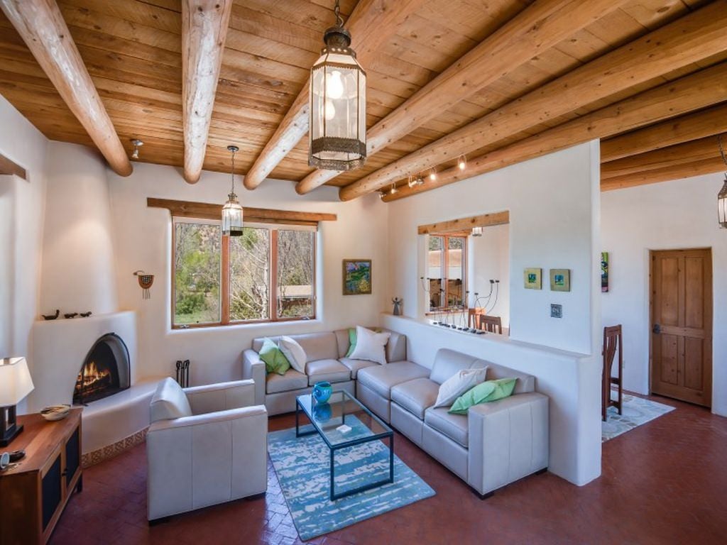 设计简单的西南客厅，原木横梁和木质天花板。它还以砖图案的地板为特色。