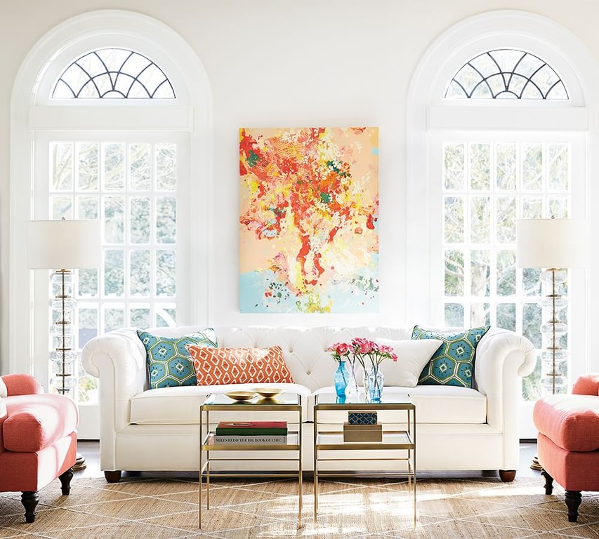 设计华丽的客厅，蓝色、红色和橙色的色调。白色沙发与后面的白墙浑然一体，没有彩色抱枕和墙画的强调。