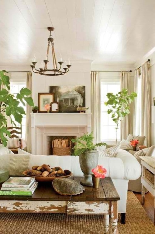 这看起来就像一个农舍的客厅，有质朴的木桌，一个古董花瓶，针织地毯，几个手工编织的篮子，还有天然的室内绿色植物。白色沙发占据了中间的空间。