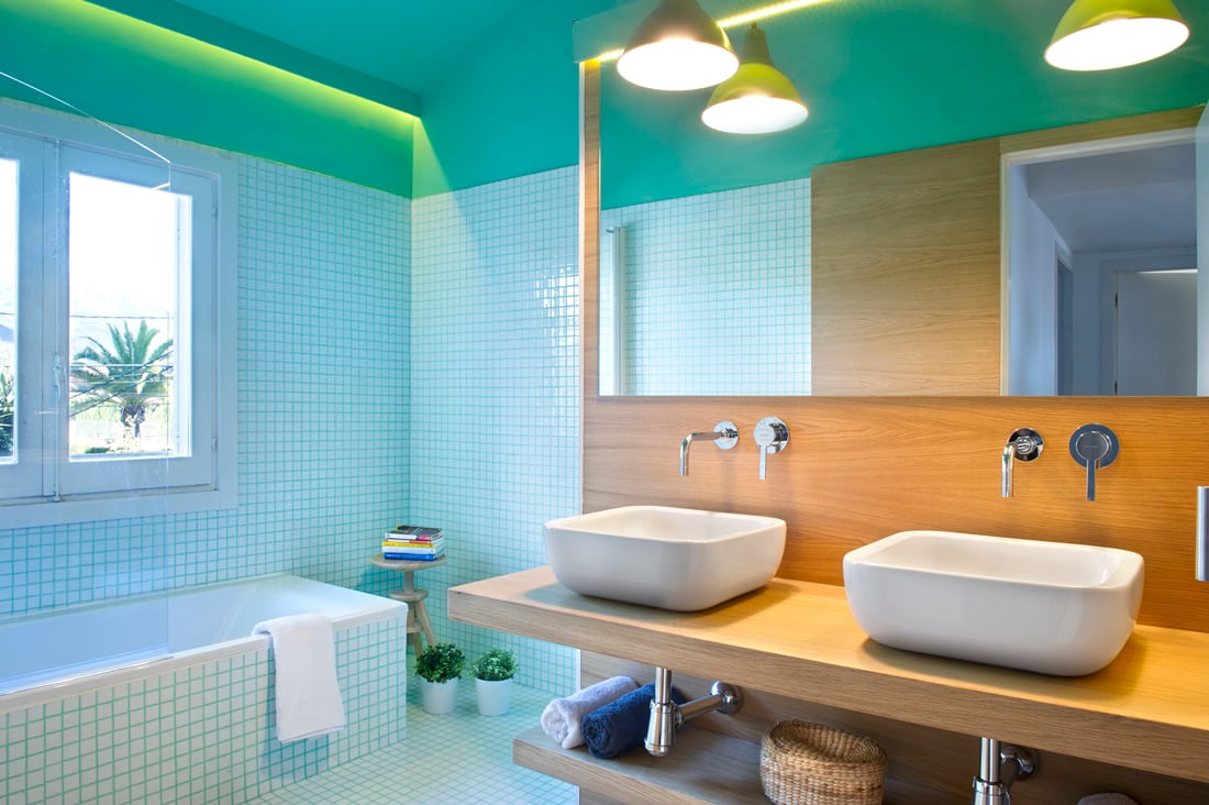 亚洲风格的设计也体现在色彩上。这个浴室以蓝绿色和浅绿色的活泼色彩为重点。而朴素的木质水槽柜台则给人一种朴实的感觉。