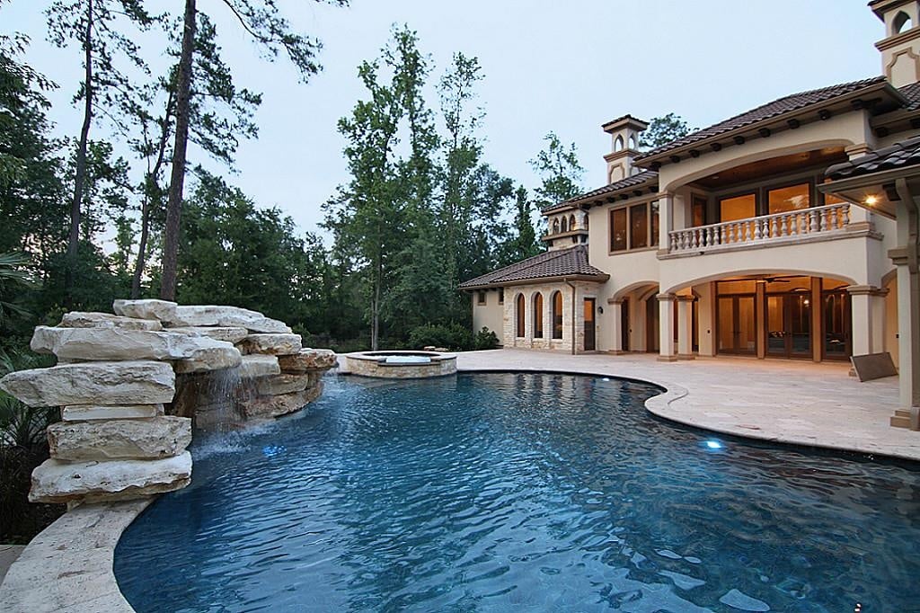 地中海风格的豪宅，大的亲切形状的游泳池和相邻的热水浴缸。
