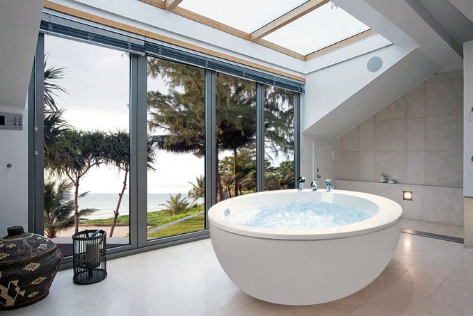 这个宽敞而放松的浴室通过地板到天花板的窗户让自然光通过而变得更加美丽。