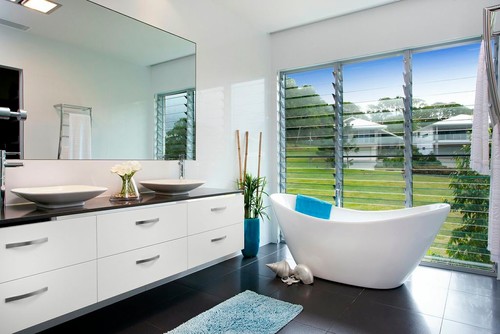 一间现代化的浴室，配有独立式浴缸、水槽、宽镜和平板橱柜。/图片来自Presentation Plus
