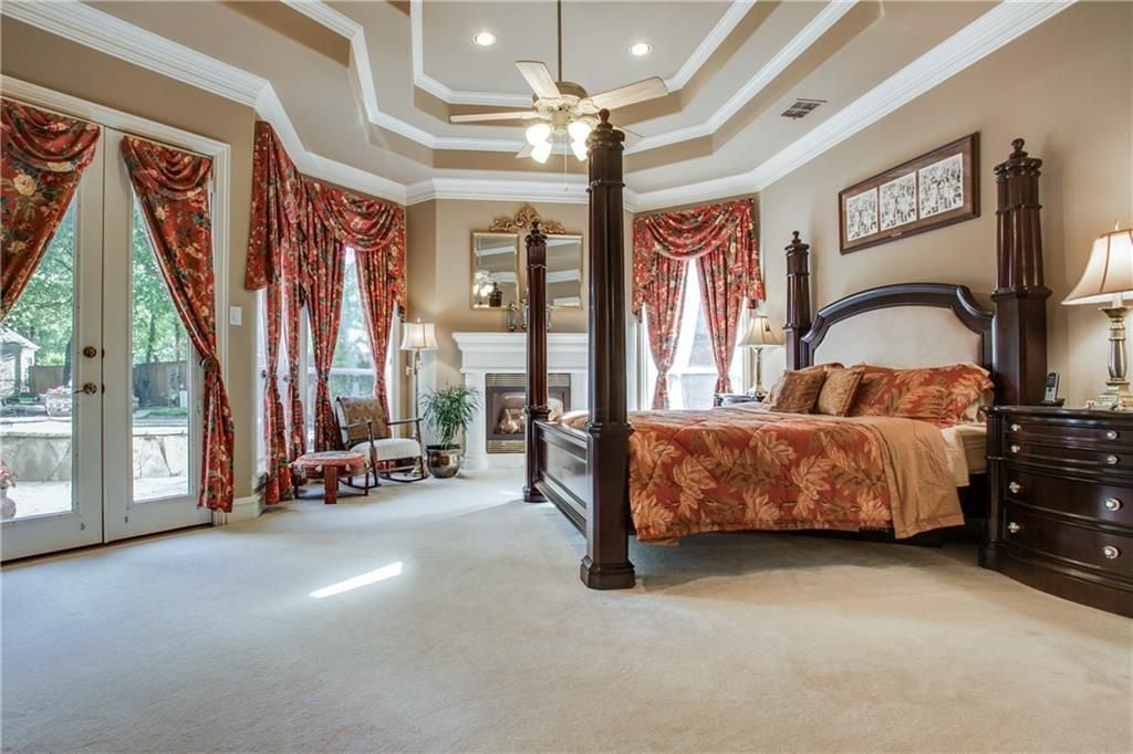 这间卧室设有豪华的床和壁炉，以及地毯地板和令人惊叹的天花板。