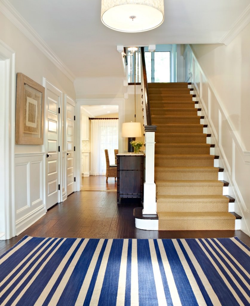 笔直的楼梯，棕色的地毯地板和白色的墙壁。