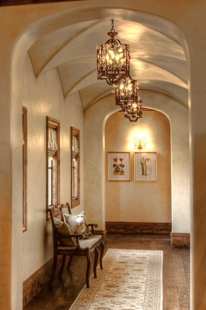 这个门厅的特点是由优雅的顶灯照明的腹股沟拱顶天花板。旁边的椅子看起来很漂亮。