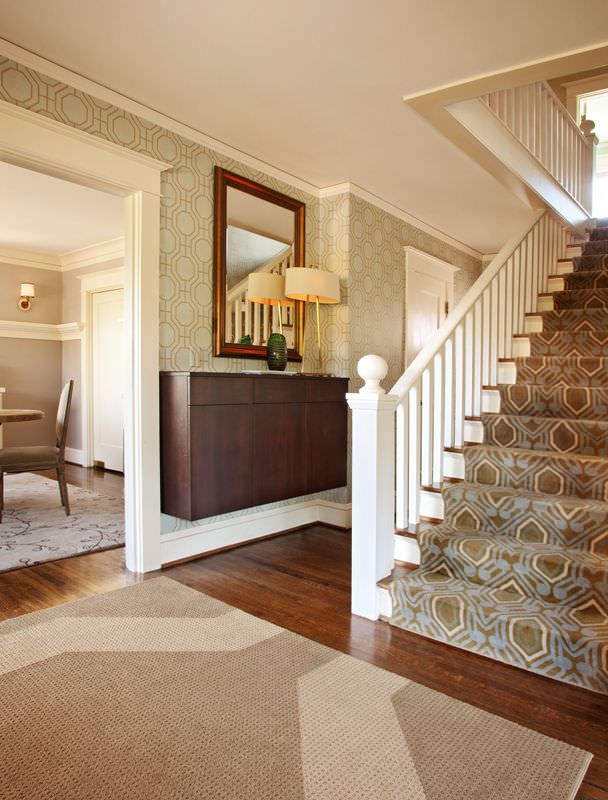 一条笔直的楼梯，铺着华丽的地毯，白色的栏杆和扶手。