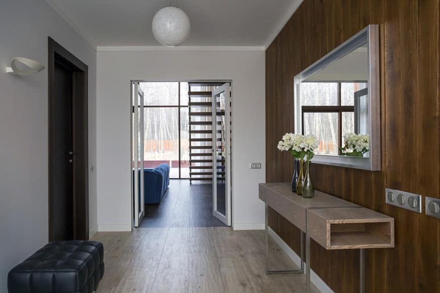 这个门厅的特点是硬木地板，白色和木墙和一个黑色的奥斯曼椅额外的风格。