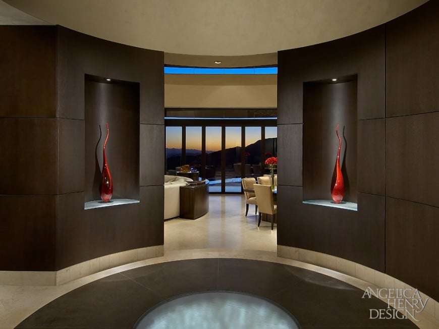 这个豪华的门厅展示了圆形地板，并配有光纤照明。深棕色的墙壁上装饰着可爱的红色装饰。
