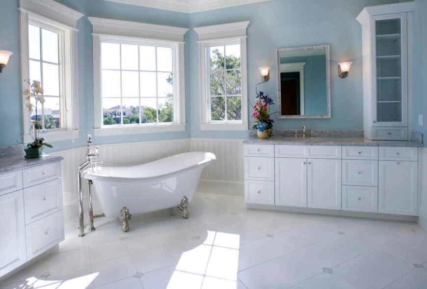 主浴室设有一个独立的爪足浴缸，瓷砖地板，壁挂式灯具和木制橱柜。