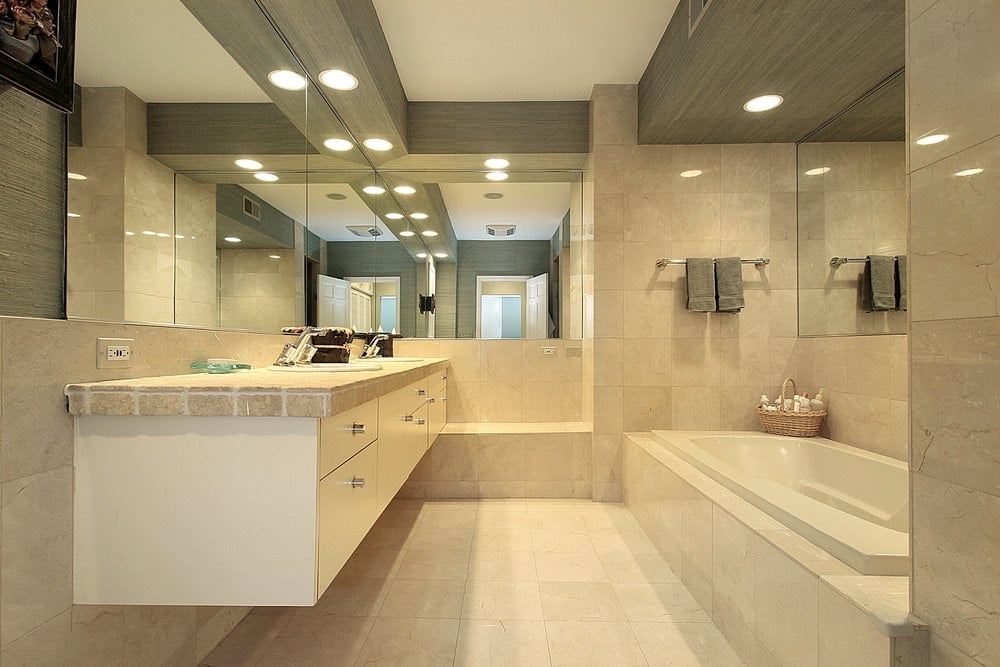 主浴室的一侧有一个落地式浴缸，还有一个带双水槽的浮动梳妆台，周围环绕着优雅的瓷砖墙壁和地板。