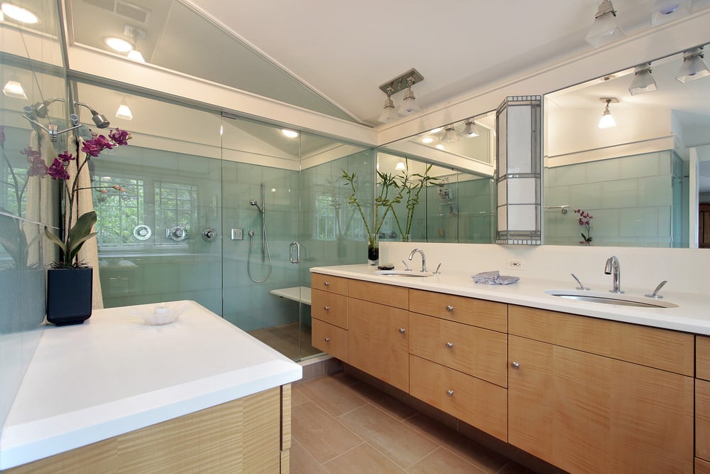 一间主浴室，提供双下置式水槽和一间带高棚天花板的大型步入式淋浴房。