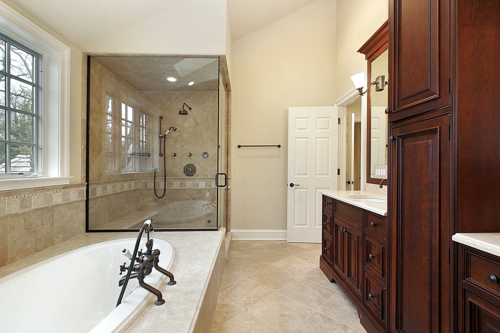 这间主浴室设有一间靠近窗户的深浴缸和一间大的步入式淋浴房，以及一个独立的水槽。