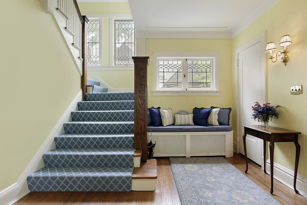 这所房子有一个l形的楼梯，上面铺着蓝色的高级地毯。栏杆的框架是用硬木做的。