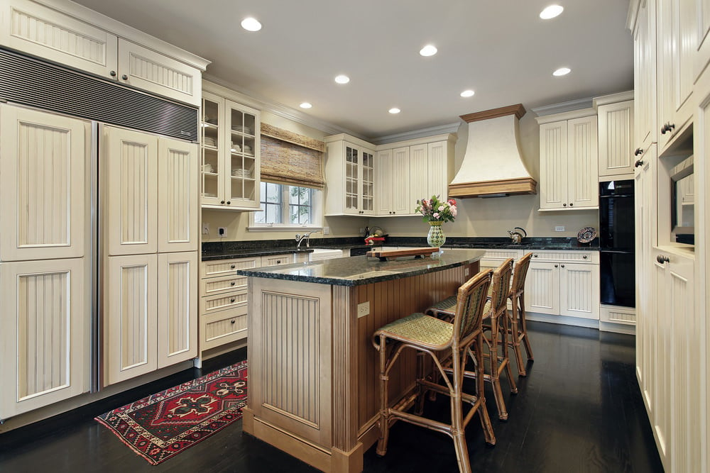 这个传统的厨房拥有深色硬木地板和黑色优雅的花岗岩台面。
