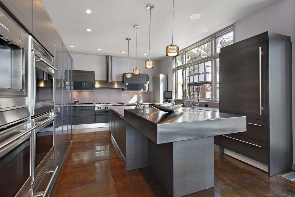 现代厨房设有时尚的灰色橱柜和中央岛台，还有棕色的地板和普通的天花板，由嵌入式和吊灯照明。