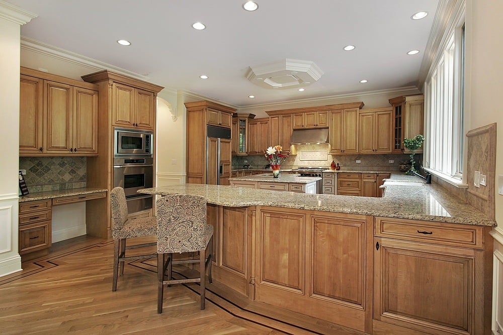 这间厨房配有配套的胡桃木橱柜和地板。大理石台面铺满了厨房。