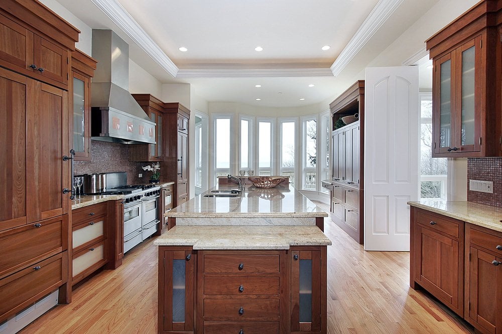 白色传统厨房与樱桃口音。大理石台面看起来也很优雅，而托盘天花板看起来很惊艳。