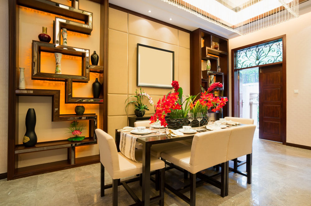 豪华的亚洲风格的餐厅，托盘天花板，装饰华丽的内置货架，和一套六人用餐。