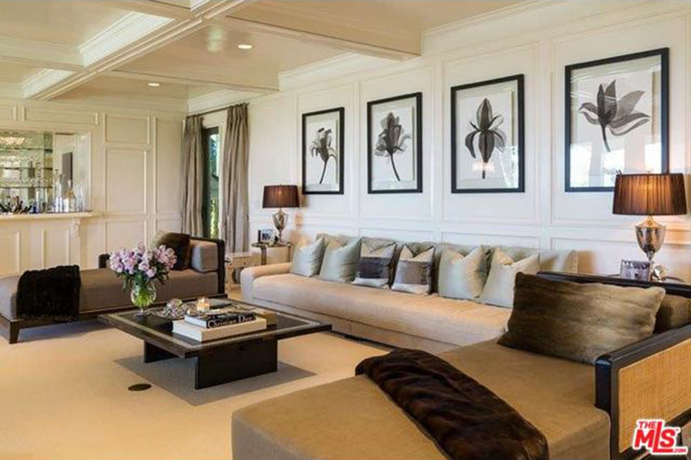 正式的客厅装饰有一系列花墙艺术，安装在白色护壁板上，与方格天花板相辅相成。