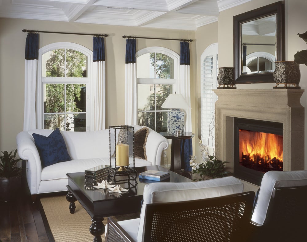 一个优雅的客厅设置舒适和优雅的座位靠近壁炉。米色的墙壁和棕色的硬木地板搭配起来很完美。