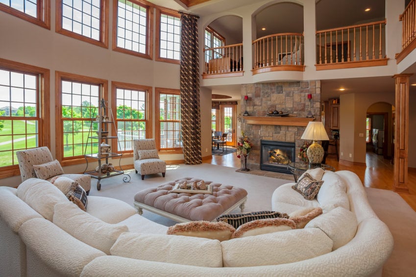 一个优雅的客厅，一个迷人的白色沙发设置在一个大地毯。还有一个壁炉来保持温度。高高的天花板使房子看起来美极了。