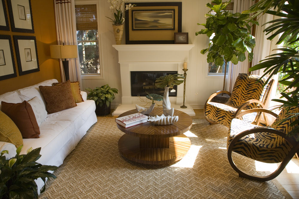 客厅里有一个热带审美的木制结构的口音椅子,编织地毯、盆栽植物,整个空间包括一个橙色和地球音调口音。空间也有一个壁炉,沙发和木制线轴的咖啡桌。