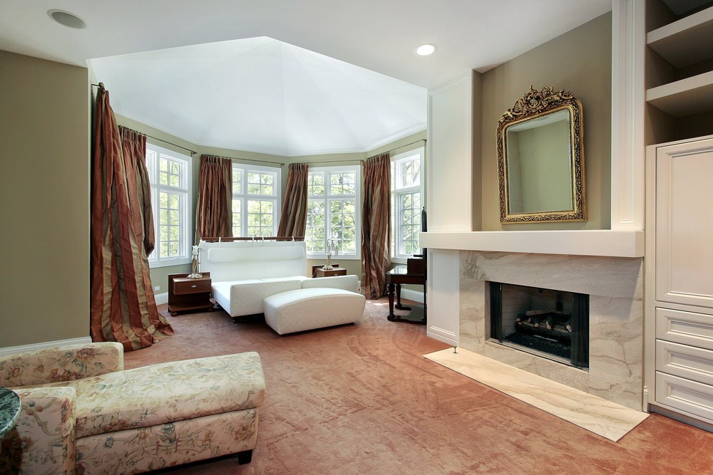 大主卧室，有一张吸引人的床和一个大壁炉前的休息区。房间的特色是棕色地毯地板。