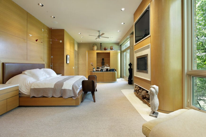 这间主卧室拥有一张大床和一个办公区域，以及一个时尚的壁炉。该房间还设有地毯地板和玻璃窗。